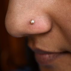 a woman's nose with a tiny white pearl on it