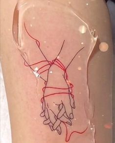 a woman's legs with red string wrapped around her ankles and hand drawn on them