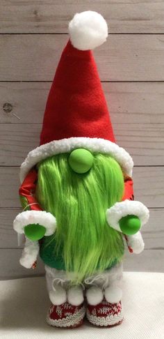 a green stuffed animal wearing a santa hat