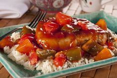 a blue plate topped with rice covered in meat and veggies next to a fork