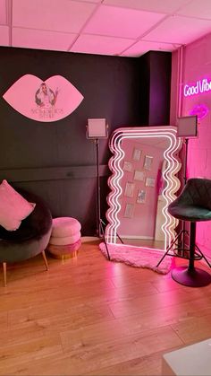 a room with pink lighting and black furniture