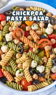 a white bowl filled with pasta salad on top of a blue table