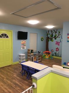 a classroom with blue walls and green doors, white desks and yellow door on the wall