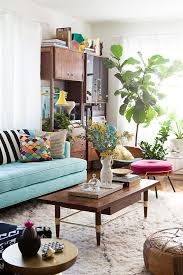 a living room filled with furniture and lots of plants on the table in front of it