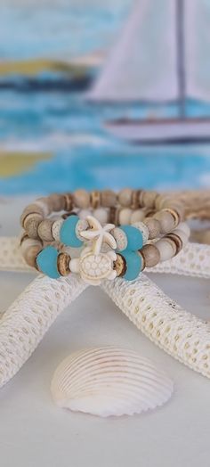 TitiTataStore.com Always FREE SHIPPING and a FREE GIFT! I Will Ship Within 24 Hours! Description: A set of 2 Coastal Style Beach Bracelets. The perfect accessory for that beach getaway vacation trip!  Materials:  8mm Natural Sandalwood Beads, 8mm Natural Wood Beads, Ocean Blue Cultured Sea Glass Nuggets Beads, 8mm Heishi Coconut Beads, and 8mm Lava Rock Heishi Beads.  A Sea Turtle and a Starfish charm adorned this Beachy set.  A high-quality elastic stretch cord is used to string the beads toget Cheap Round Stretch Bracelet For Beach, White Coastal Style Bracelet For Gift, Spiritual White Friendship Bracelets For Beach, Sand-colored Adjustable Bracelet For Gift, Adjustable Sand-colored Bracelet Gift, Coastal Bracelet, Ocean Theme Crafts, Burlap Gift Bags, Girls Trip Gifts