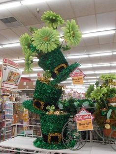 a display in a store filled with lots of green decorations and flowers on top of it