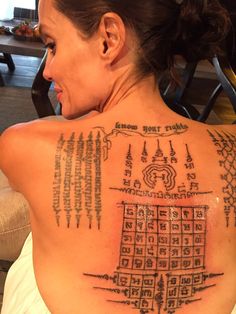 the back of a woman's upper body with many symbols and numbers on it