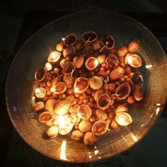 a bowl filled with nuts and lit candles