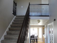 the stairs in this house lead up to the dining room table and bar area on the second floor