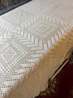 a bed with a white bedspread sitting on top of a red carpeted floor