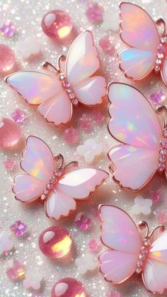 several pink butterflies are sitting on some glittery material and one is in the shape of a butterfly