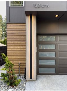 the front entrance to a modern home with wood siding