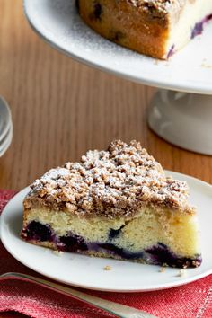 a slice of blueberry crumb coffee cake on a white plate with a fork