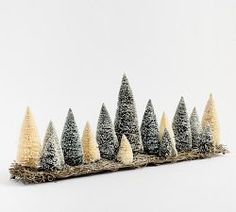 a row of small trees sitting on top of a snow covered ground