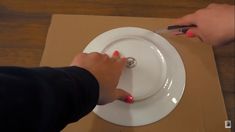 a person is using a knife and fork to cut something out of a paper plate