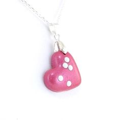 Choose any 1-2 letters in braille on this adorable heart shaped pendant. The necklace is made out of polymer clay in a silver plated bail/loop with your choice of clay color. It comes with a choice of silver plated chain or leather cord (18-20 inches) and white or black metal dots. The pendant is sealed with a coat of glaze. The heart measures 1-3/8 inches tall (35mm) including bail/loop 1 inches across (25 mm) This example is made of medium (2 letter) and dark (1 letter) magenta clay but can be White Heart Charm Necklace For Birthday, White Heart Necklace For Birthday, White Heart-shaped Polymer Clay Jewelry, Heart Beads Polymer Clay Jewelry Gift, Silver Polymer Clay Pendant Necklace, Nickel-free Polymer Clay Necklace Gift, Small Polymer Clay Jewelry As Gift, Cute Nickel-free Heart-shaped Necklace, Cute Nickel-free Heart Necklace