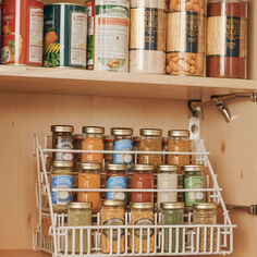 an organized spice rack in a kitchen with spices and seasonings on the top shelf