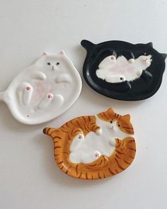 three ceramic cats sitting next to each other