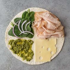 a plate with meat, cheese and spinach on it next to other food items