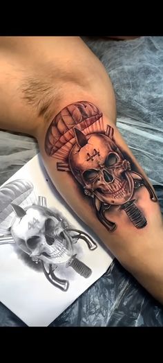 a man's arm with a skull and parachute tattoo on it