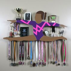 a wall mounted display with medals and other items on it's sides, including an athlete figure