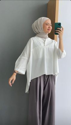 a woman wearing a hijab taking a selfie