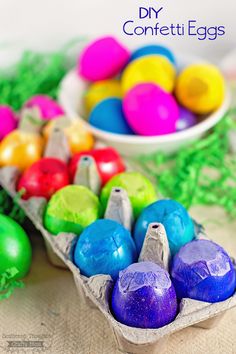 there are many different colored eggs in the carton on the table next to each other