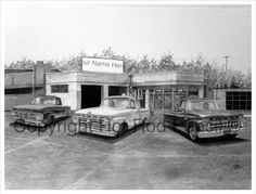 three old cars are parked in front of a gas station with a sign that says mr name here