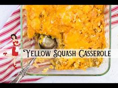 yellow squash casserole in a glass dish with a serving spoon and red striped napkin