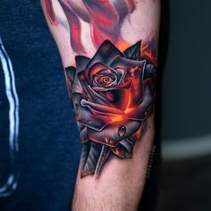 a man's arm with a rose on it and flames coming out of it