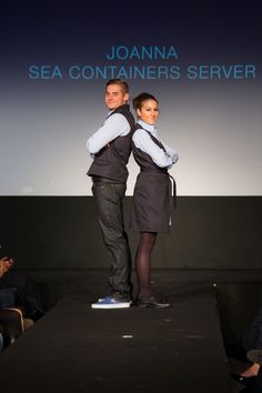 two people standing on a runway with their arms around each other while one person holds his back