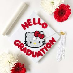 a hello kitty graduation cap with the words hello graduation on it next to some flowers