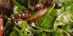 a salad with spinach, strawberries and feta cheese on top is ready to be eaten