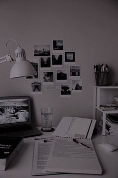 an open laptop computer sitting on top of a desk next to a stack of books