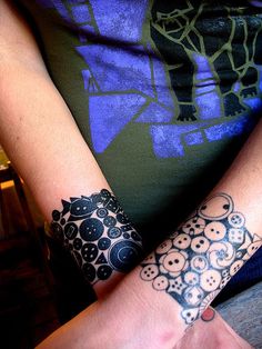 two people with tattoos on their arms and wrist are holding each other's hands