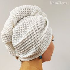 a woman's head wearing a white knitted hat with blue beads on it