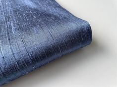 a close up of a blue cloth on a white surface with space for text or image