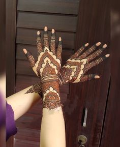 a woman's hand with henna on it is shown in front of a door