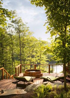 a hot tub sitting on top of a wooden deck next to a tree filled forest