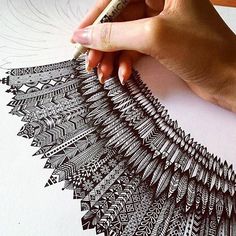 someone is drawing an intricate design on paper