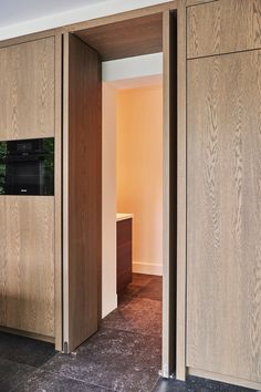 an open door leading into a room with wood paneling on the walls and floor