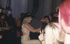 a woman in white pants and a cowboy hat is dancing with her hands out to the crowd