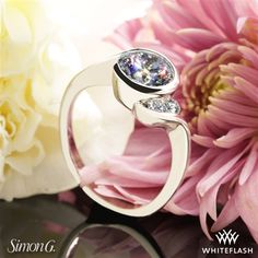 a close up of a ring with flowers in the background