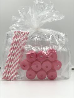 pink and white striped paper straws in plastic bag