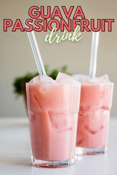 two glasses filled with pink liquid sitting on top of a table