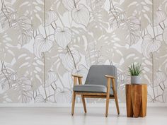 a chair sitting next to a potted plant in front of a wall