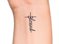 a wrist tattoo with the word jesus written in cursive writing on it's side