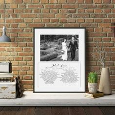 a wedding poem is displayed on a shelf next to a brick wall and potted plants