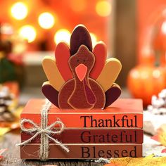 a wooden turkey sitting on top of two books that say, thank grateful and be loved