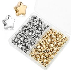 two pairs of gold and silver colored metal beads in a plastic container with star shaped studs